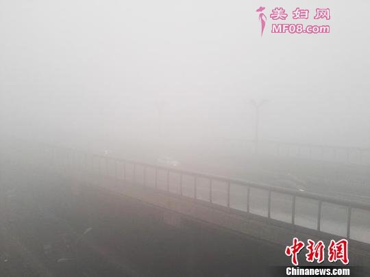 12月9日，18时乌鲁木齐东西外环受浓雾影响，能见度不足100米，车辆开启雾灯缓慢通行。 王小军 摄
