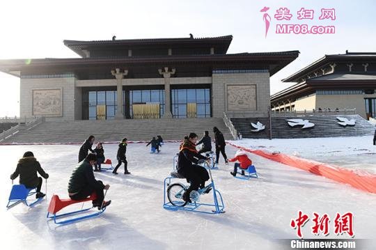 图为游人畅玩鸣沙山下的滑冰场。 杨园敏 摄