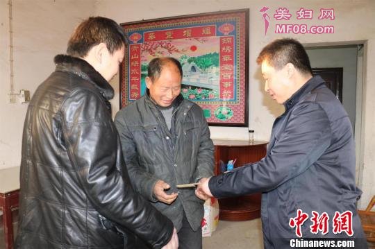 困难农户收到爱心企业捐赠的善款。 孔小娟 摄