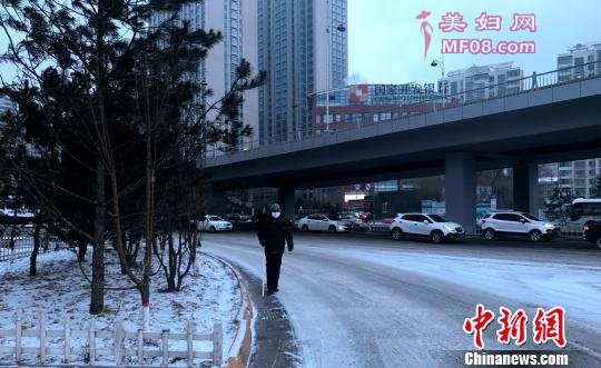 由于道路结冰，市民缓慢的在街上行走。 孙睿 摄