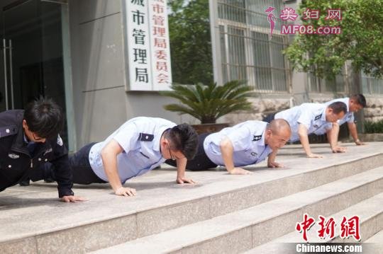 副大队长兼六片区片长汤惠朝(中)与队员一起罚做俯卧撑。 李溪轮 摄