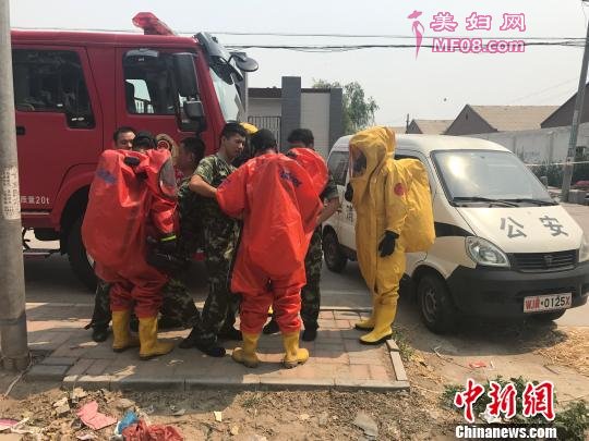 无极县公安局工作人员穿上防化服进入现场调查 张帆 摄