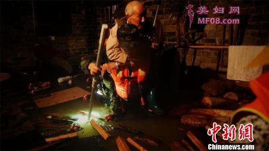 救援人员将老人背出遭洪水围困的住处 刘森淼 摄